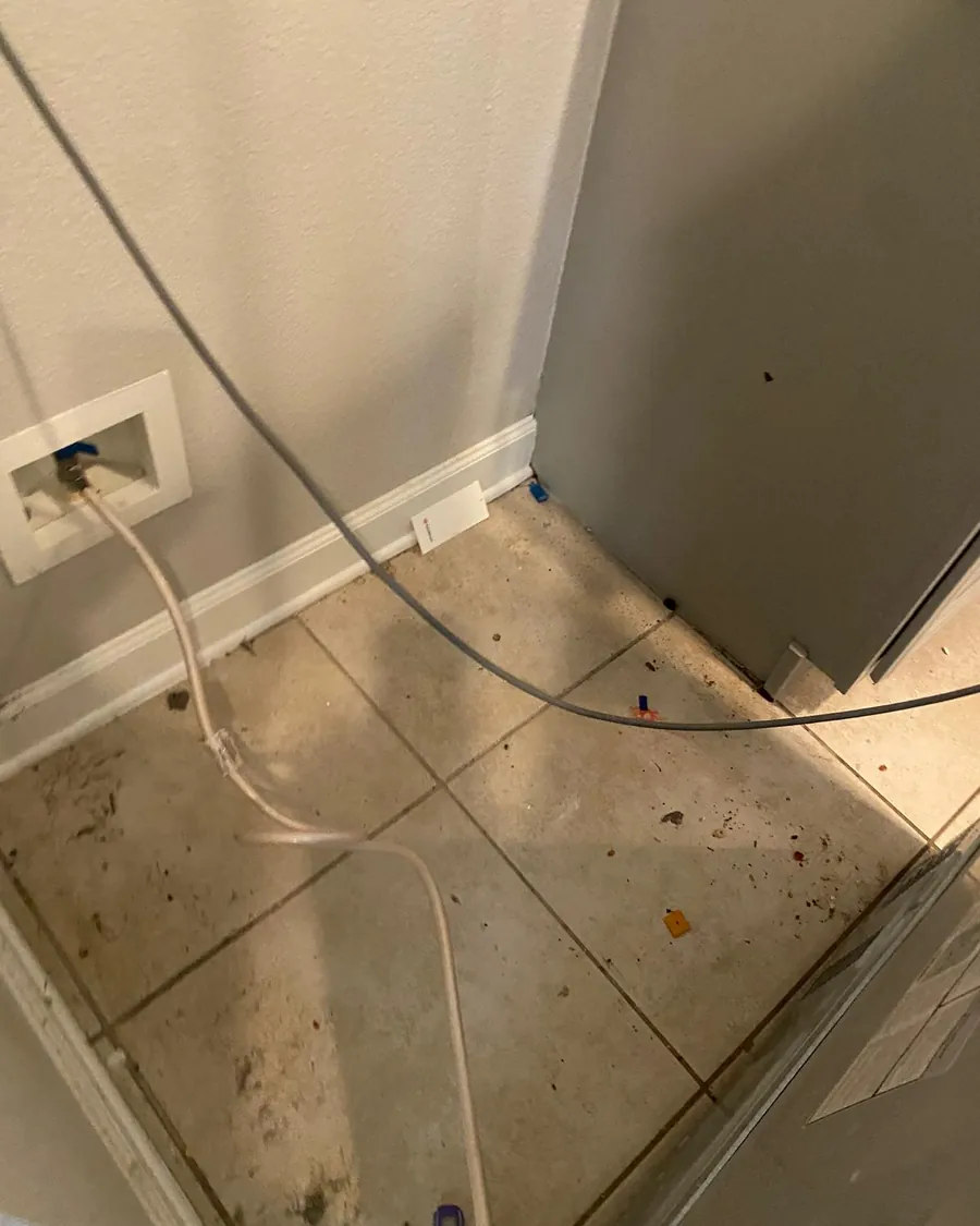 Grimy floor corner behind an appliance before deep cleaning