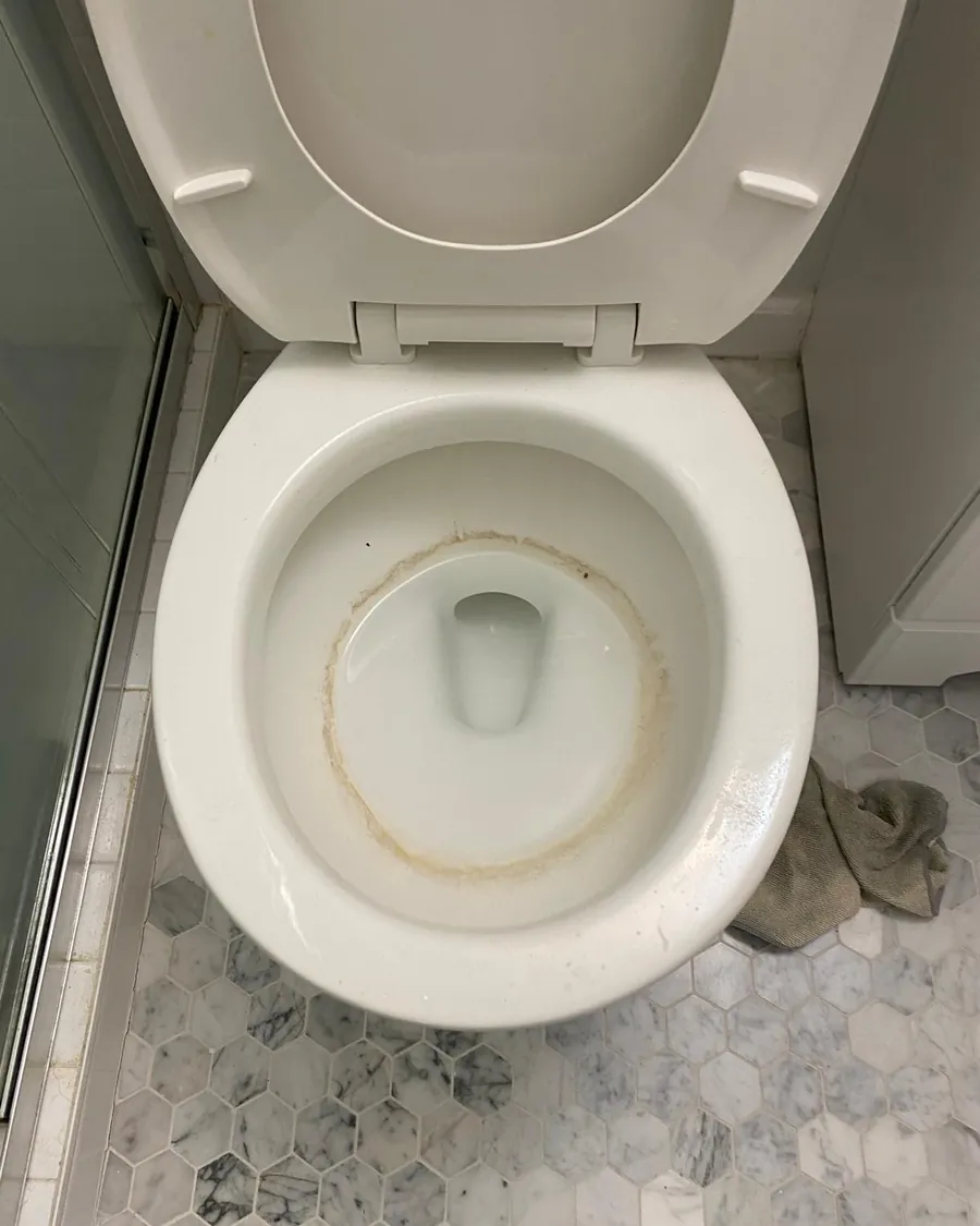 Toilet bowl with hard-water stains before deep cleaning
